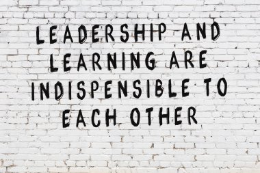 Bilgece alıntıların yazılı olduğu siyah boyanmış beyaz tuğla duvar