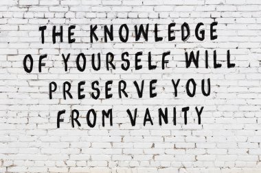 Beyaz tuğla duvar arkaplanına siyah düşünceli bir yazı.