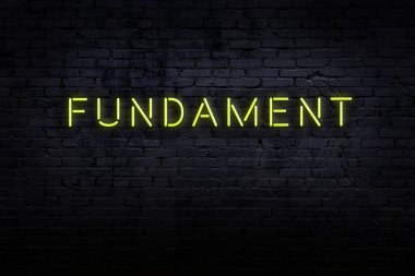 Neon işareti. Kelime temeli tuğla duvara karşı. Gece görünümü