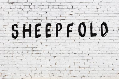 Üzerinde siyah boya yazıları olan beyaz duvar.