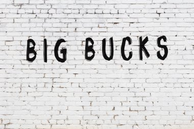 Beyaz tuğla duvara büyük paralar kazınmış.