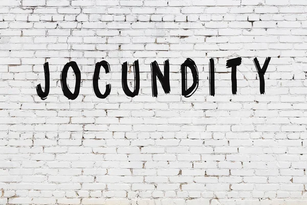 Nápis jocundity namalované na zdi z bílých cihel — Stock fotografie