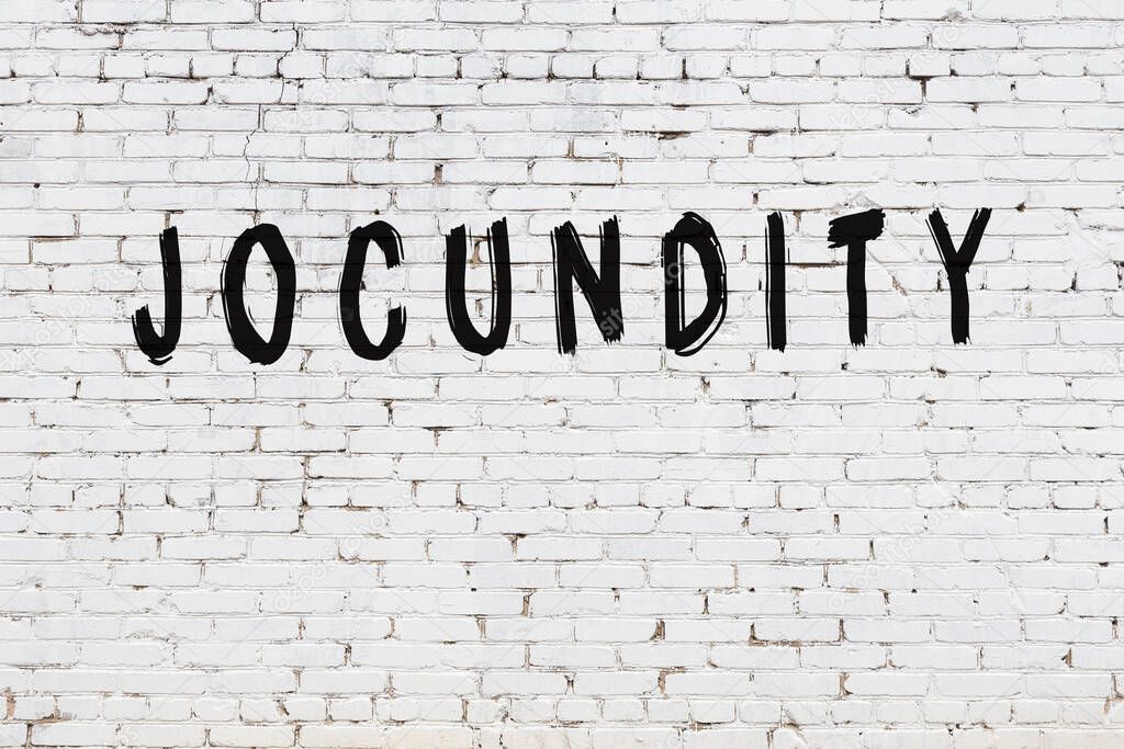 Inscription jocundity painted on white brick wall