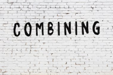 Yazı, beyaz tuğla duvarda boyanmış.