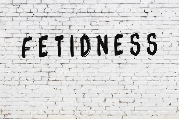 Üzerinde siyah boya saplantısı olan beyaz bir duvar.