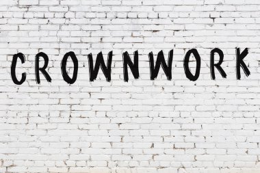 Beyaz tuğla duvara kazınmış bir yazı.