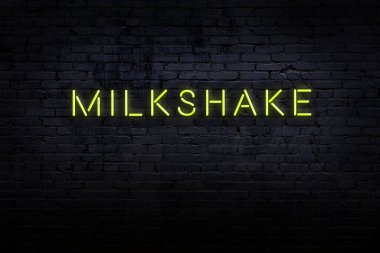Üzerinde milkshake yazan tuğla duvardaki neon levhanın gece görüşü