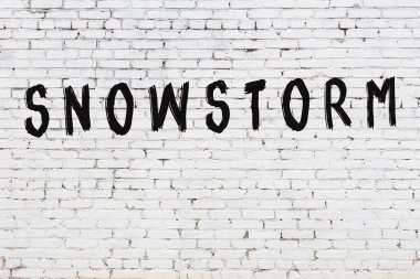 Beyaz tuğla duvara kar fırtınası yazılmış.