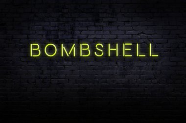 Neon işareti. Kelime bombası tuğla duvara karşı. Gece görünümü