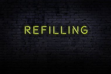 Neon işareti. Kelime tuğla duvara karşı doluyor. Gece görünümü