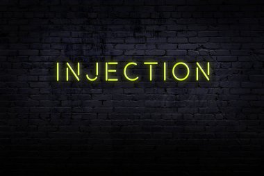 Neon işareti. Duvara karşı kelime enjeksiyonu. Gece görünümü