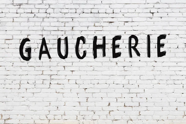 Üzerinde siyah boya yazıtları olan beyaz duvar.