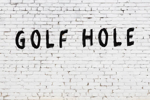 Vit vägg med svart färg inskription golfhål på den — Stockfoto