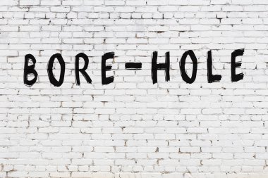 Beyaz tuğla duvara kazınmış bir delik.