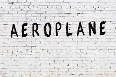 Beyaz tuğla duvara kazınmış bir uçak.