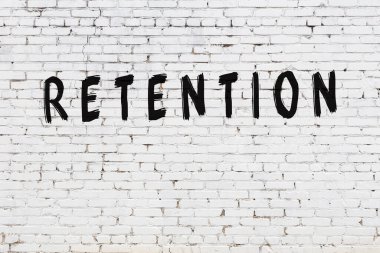 Beyaz tuğla duvara kazınmış yazı kalıntısı.