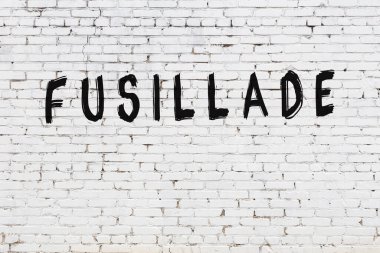 Üzerinde siyah boya tabelaları olan beyaz duvar.