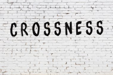 Beyaz tuğla duvara kazınmış bir yazı.