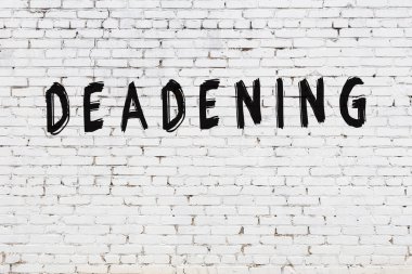 Üzerinde siyah boya yazıları olan beyaz bir duvar.