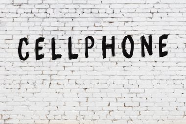 Beyaz tuğla duvara yazılmış bir cep telefonu.