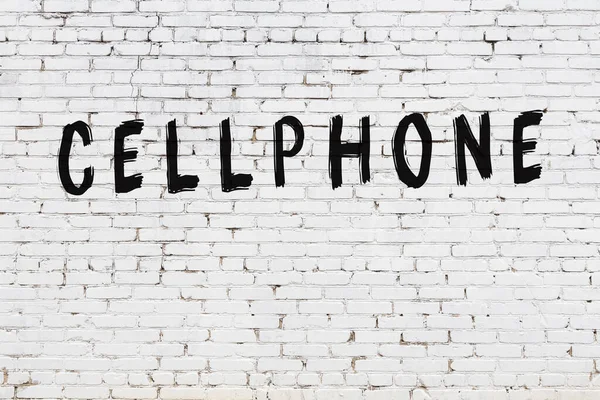 Beyaz tuğla duvara yazılmış bir cep telefonu.