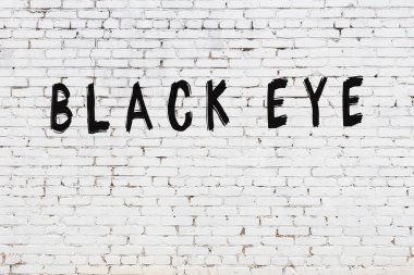 Üzerinde siyah boya yazılı beyaz bir duvar.