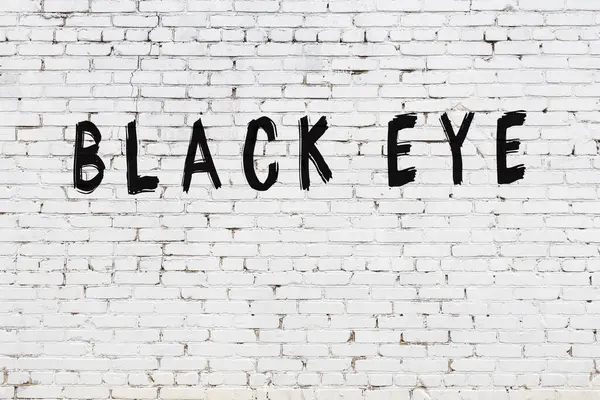 Üzerinde siyah boya yazılı beyaz bir duvar.