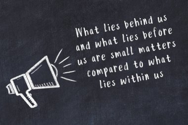 Tebeşir hoparlörü ve siyah masada akıllıca bir alıntı.