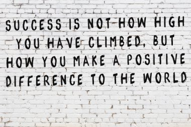 Beyaz tuğla duvar arkaplanına siyah düşünceli bir yazı.