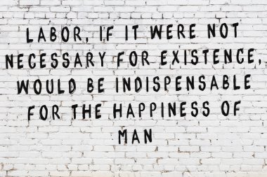 Beyaz tuğla duvar arkaplanına siyah düşünceli bir yazı.