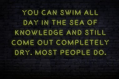 Tuğla duvardaki neon ışığın gece görüşü. Bilge Qoutation. 