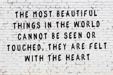 Bilgece alıntıların yazılı olduğu siyah boyanmış beyaz tuğla duvar