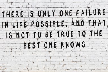 Bilgece alıntıların yazılı olduğu siyah boyanmış beyaz tuğla duvar