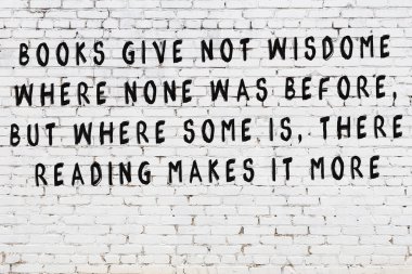 Beyaz tuğla duvar arkaplanına siyah düşünceli bir yazı.