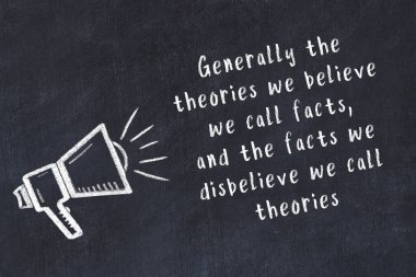 Tebeşir hoparlörü ve siyah masada akıllıca bir alıntı.