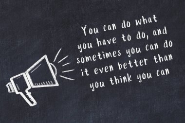 Tebeşir hoparlörü ve siyah masada akıllıca bir alıntı.