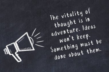 Tebeşir hoparlörü ve siyah masada akıllıca bir alıntı.