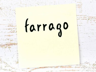 Tahta duvarda el yazısıyla yazılmış Farrago yazan sarı yapışkan bir not.
