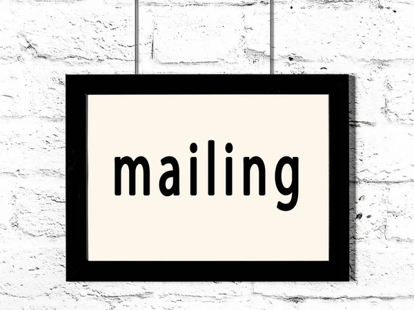 Černý rám zavěšený na zdi z bílých cihel s nápisem mailing — Stock fotografie