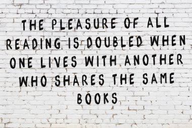 Bilgece alıntıların yazılı olduğu siyah boyanmış beyaz tuğla duvar