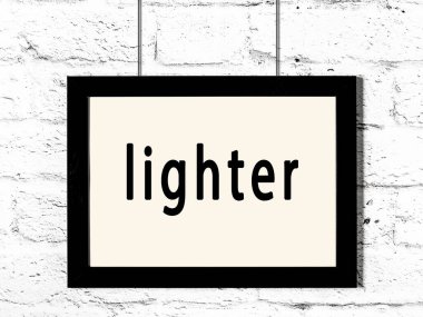 Beyaz tuğla duvarda asılı siyah çerçeve.