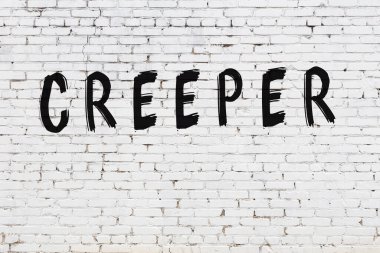 Üzerinde siyah boya yazıları olan beyaz bir duvar.