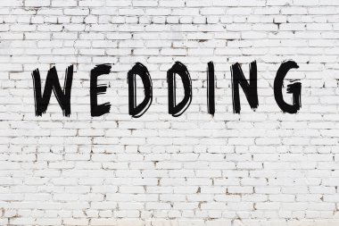 Beyaz tuğla duvara yazılmış bir düğün.