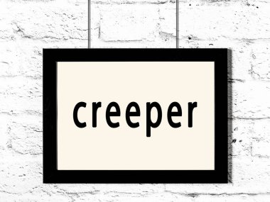 Beyaz tuğla duvarda asılı siyah çerçeve.