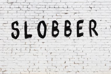 Beyaz tuğla duvara kazınmış salya.