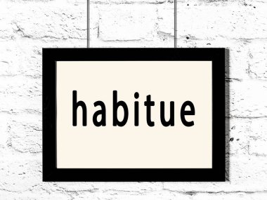 Beyaz tuğla duvarda asılı siyah çerçeve ve yazıt yerleşimi