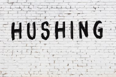 Üzerinde siyah boya yazan beyaz bir duvar.