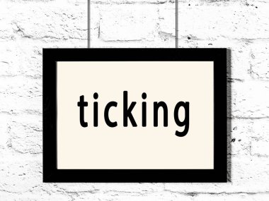 Beyaz tuğla duvarda asılı duran siyah çerçeve.