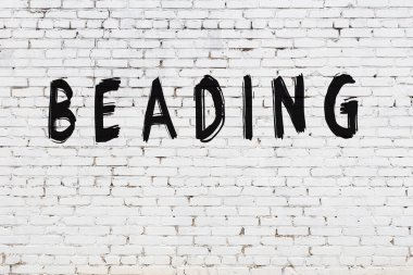 Beyaz tuğla duvara yazılı boncuk.