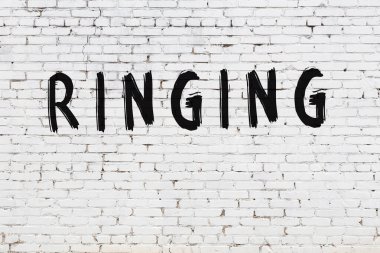 Beyaz tuğla duvarda çınlayan yazı.